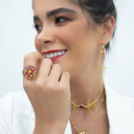 A person smiling with a ring and earrings Description automatically generated